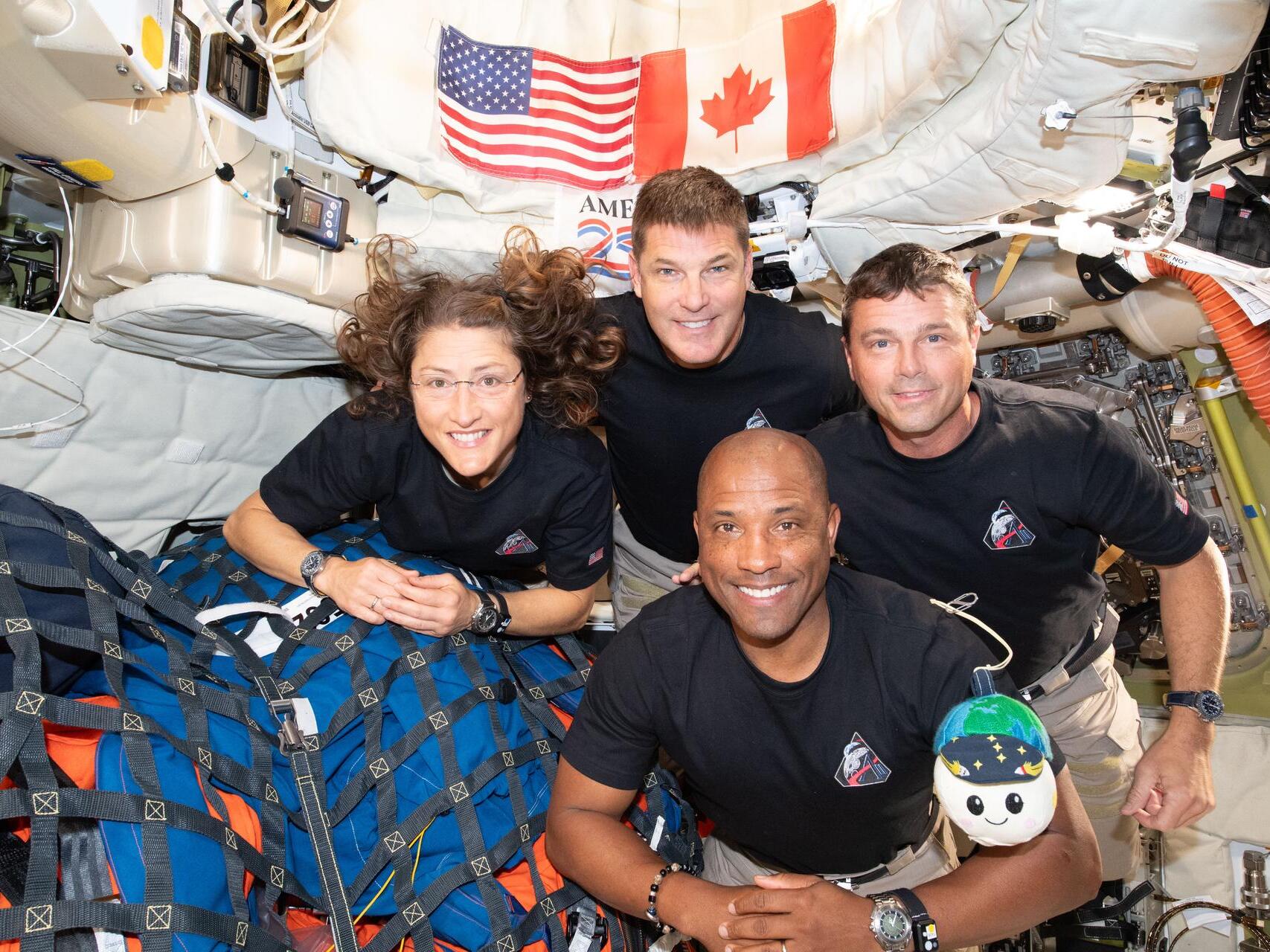 caption: The Artemis II crew — Christina Koch (left), Jeremy Hansen, Victor Glover and Reid Wiseman — have to share tight quarters aboard the Orion spacecraft on their way home. But even with limited space, they can still get a solid workout in — thanks to a very special piece of equipment.
