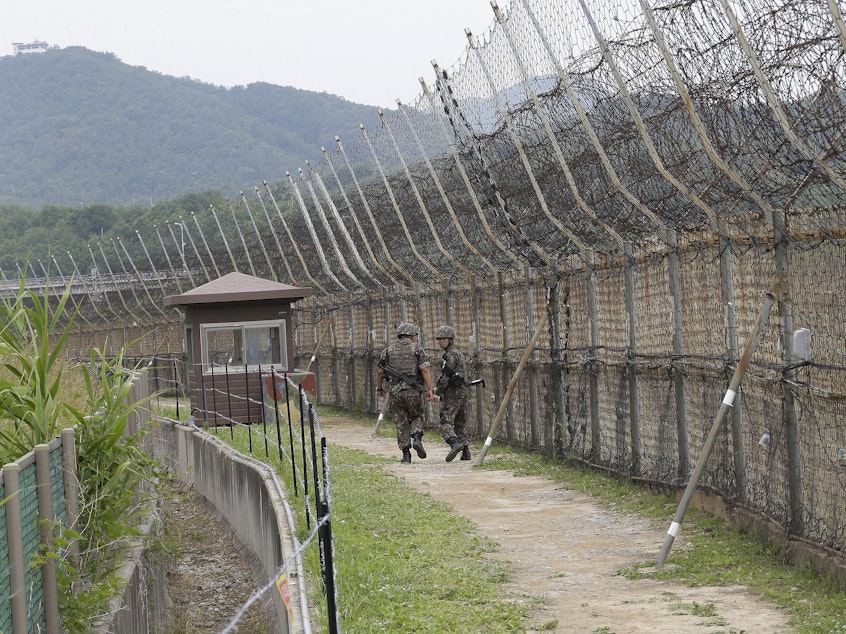 caption: South Korean soldiers patrol while hikers visit the DMZ Peace Trail in the Demilitarized Zone in Goseong, South Korea. A defector from North Korea was apprehended in Goseong last week after evading South Korean guards for hours.
