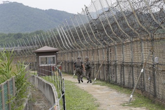 caption: South Korean soldiers patrol while hikers visit the DMZ Peace Trail in the Demilitarized Zone in Goseong, South Korea. A defector from North Korea was apprehended in Goseong last week after evading South Korean guards for hours.