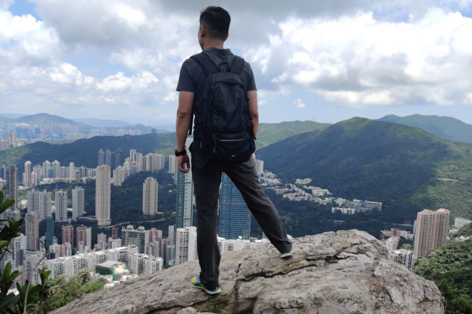 caption: Mr. Woo looks over Hong Kong, his home for most of his life. 