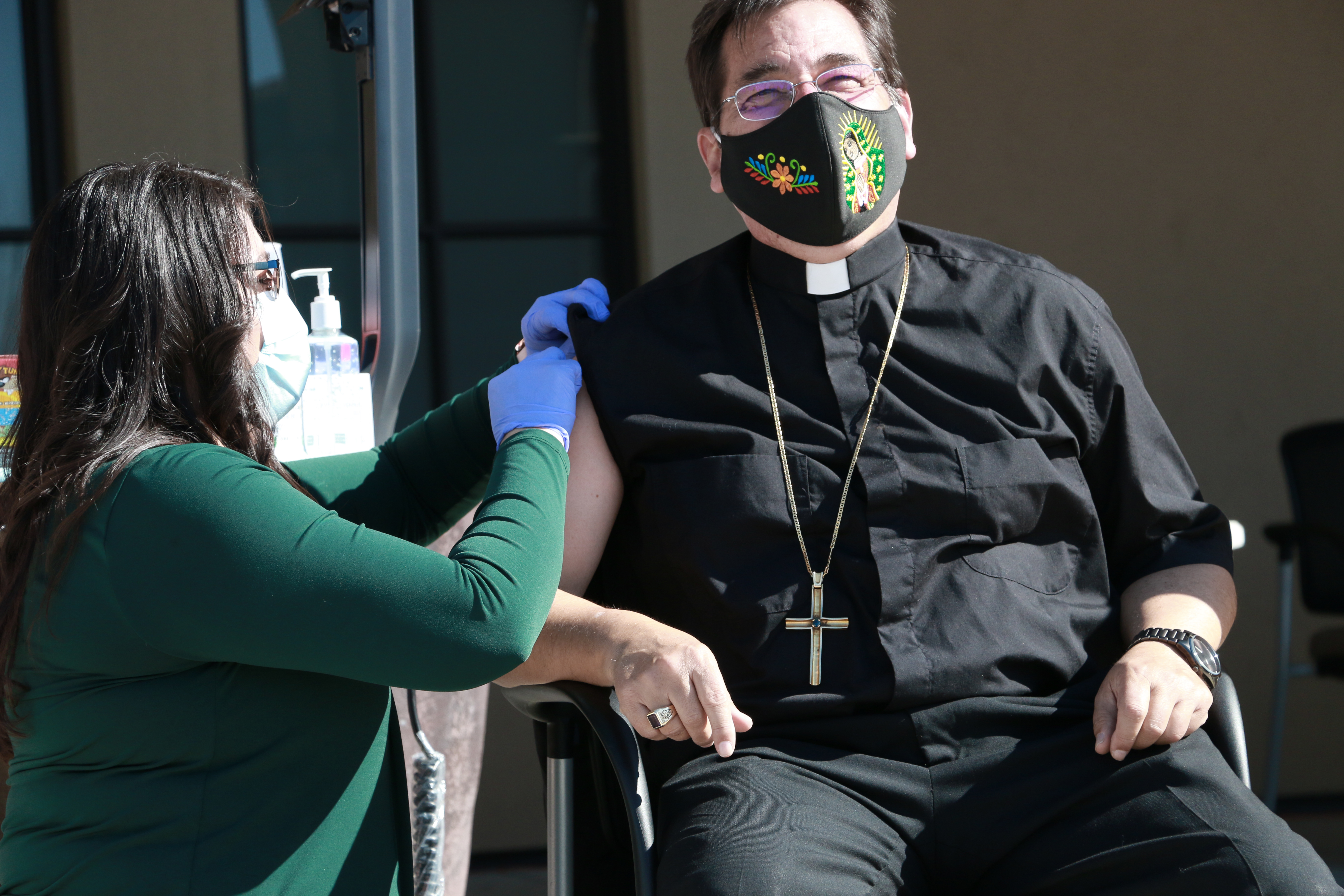 caption: Bishop Joseph Tyson of the Diocese of Yakima rolled up his robes for the COVID-19 vaccine to encourage his parishioners to do the same.