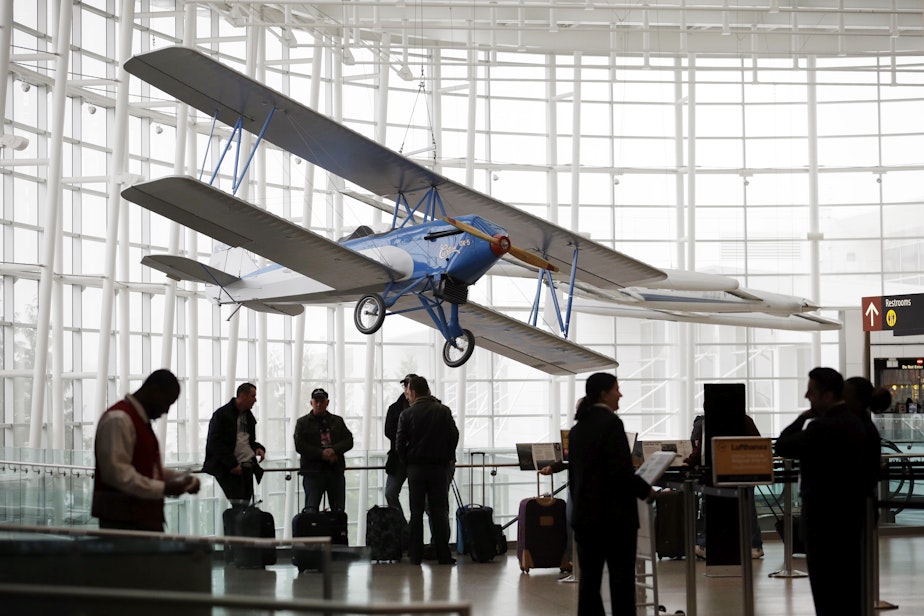 caption: In this photo taken Tuesday, Oct. 22, 2013, a biplane hangs from the ceiling of the Gina Marie Lindsey Arrivals Hall at Seattle-Tacoma International Airport in SeaTac, Wash.