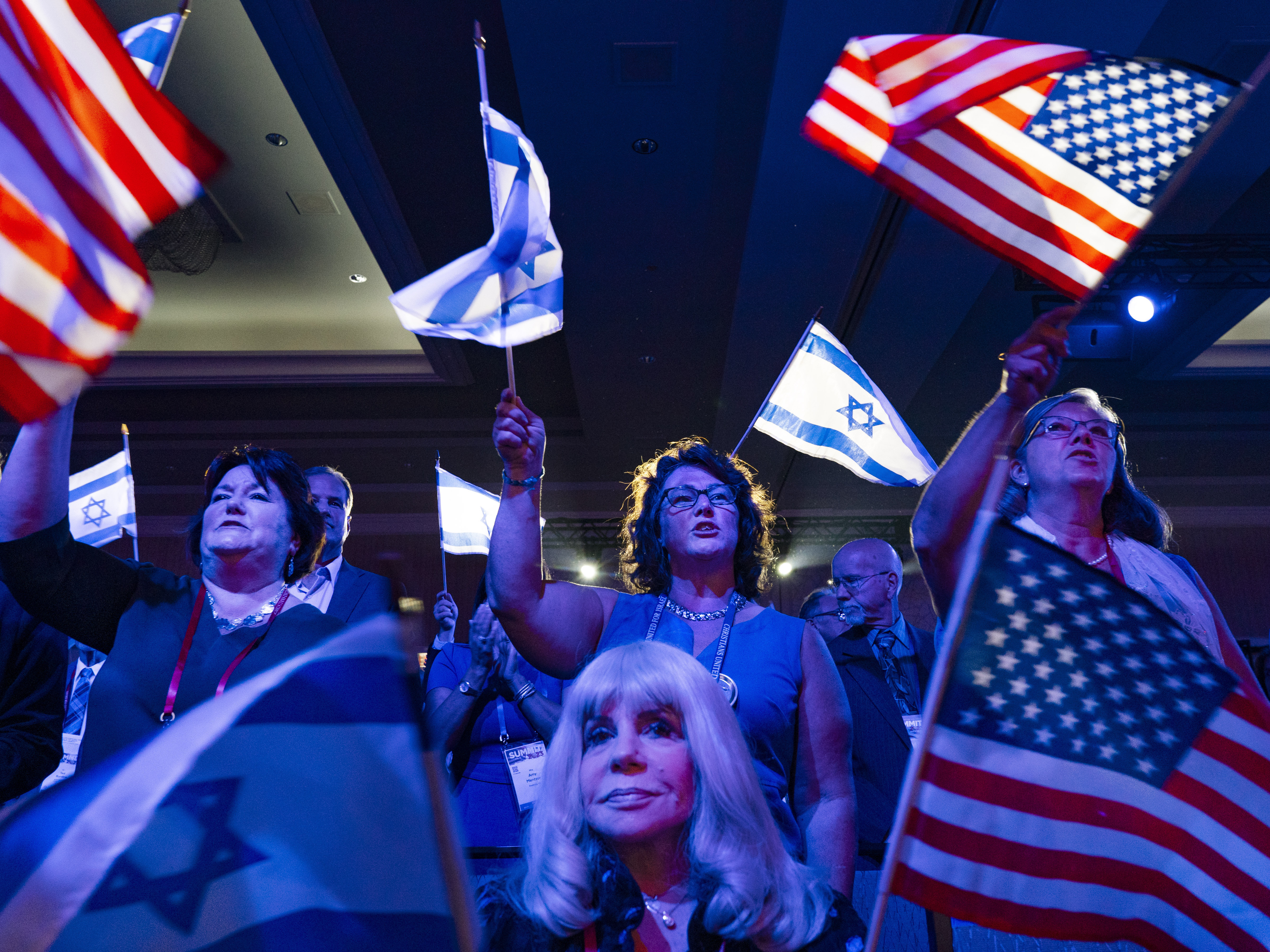 caption: A crowd of mostly Evangelical Christians waves U.S. and Israeli flags during the Christians United For Israel (CUFI) "Night to Honor Israel" event during the CUFI Summit 2023 on July 17, 2023, in Arlington, Va.