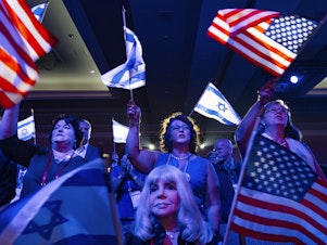 caption: A crowd of mostly Evangelical Christians waves U.S. and Israeli flags during the Christians United For Israel (CUFI) "Night to Honor Israel" event during the CUFI Summit 2023 on July 17, 2023, in Arlington, Va.