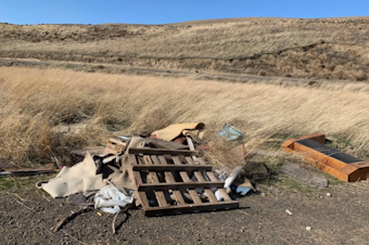 caption: Cyclists found a pile of trash near the roadside south of Kennewick. Cyclist Mike Robinson says he's seen more trash dumped by the edge of the road since the pandemic started.