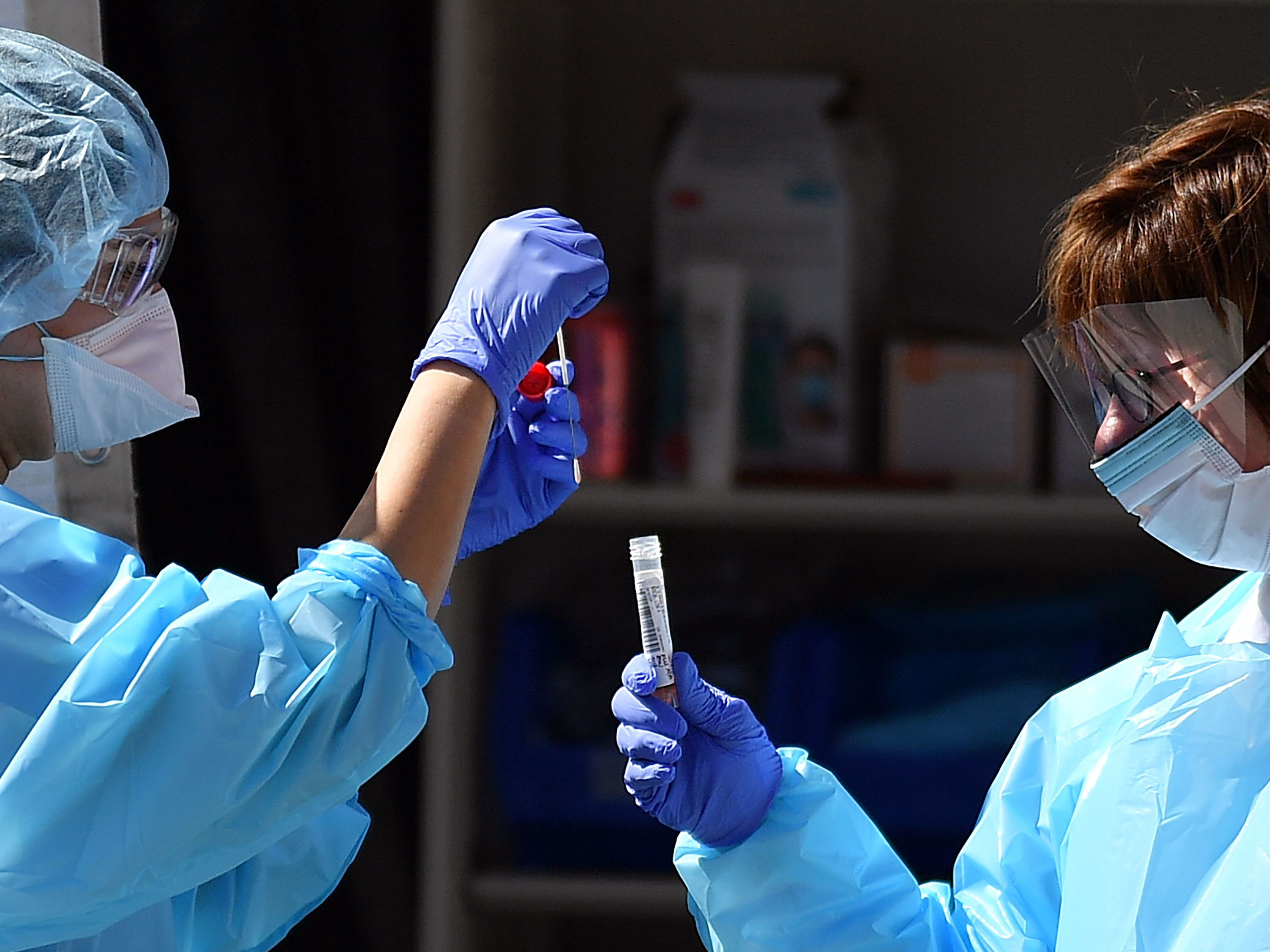caption: Medical workers at Kaiser Permanente French Campus test a patient for the coronavirus disease COVID-19 at a drive-through testing facility in San Francisco on Thursday.