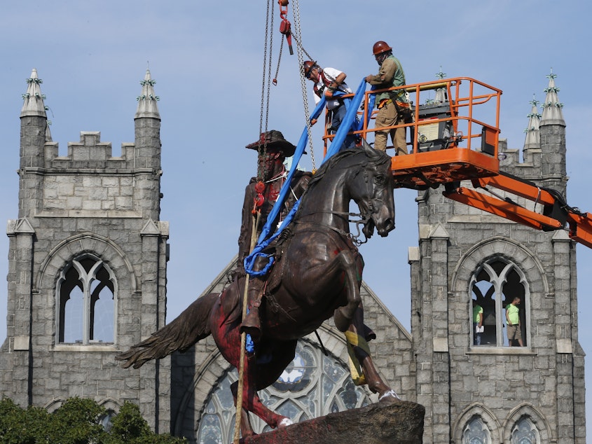 caption: Crews attach straps in July to the statue of Confederate Gen. J.E.B. Stuart in Richmond, Va. The statue was one of several that were removed by the city in 2020 following nationwide protests against systemic racism.