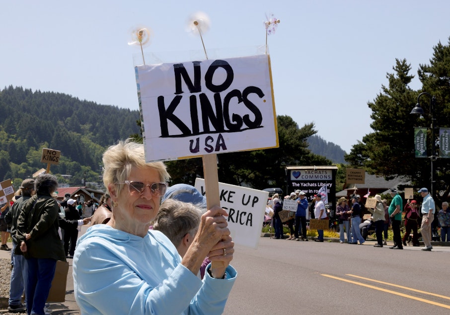 caption: Protesters along Highway 101 during the “No Kings” rally in Yachats, Ore., on Saturday, June 14, 2025.