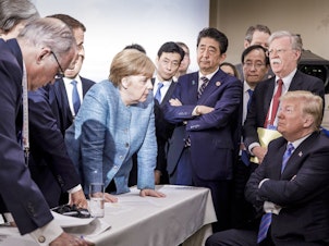 caption: Germany's Chancellor Angela Merkel (center) speaks with President Trump during the Group of Seven summit in La Malbaie, Quebec, Canada, on June 9. The Trump administration has surprised and frustrated allies in areas including trade, security, human rights and the environment.