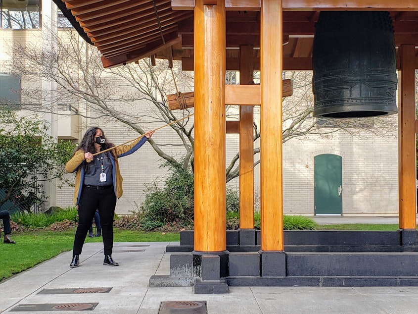 caption: Esther Lucero, of the Seattle Indian Health Board, rings The Kobe Friendship Bell in Seattle Center on Tuesday, January 19, 2021.