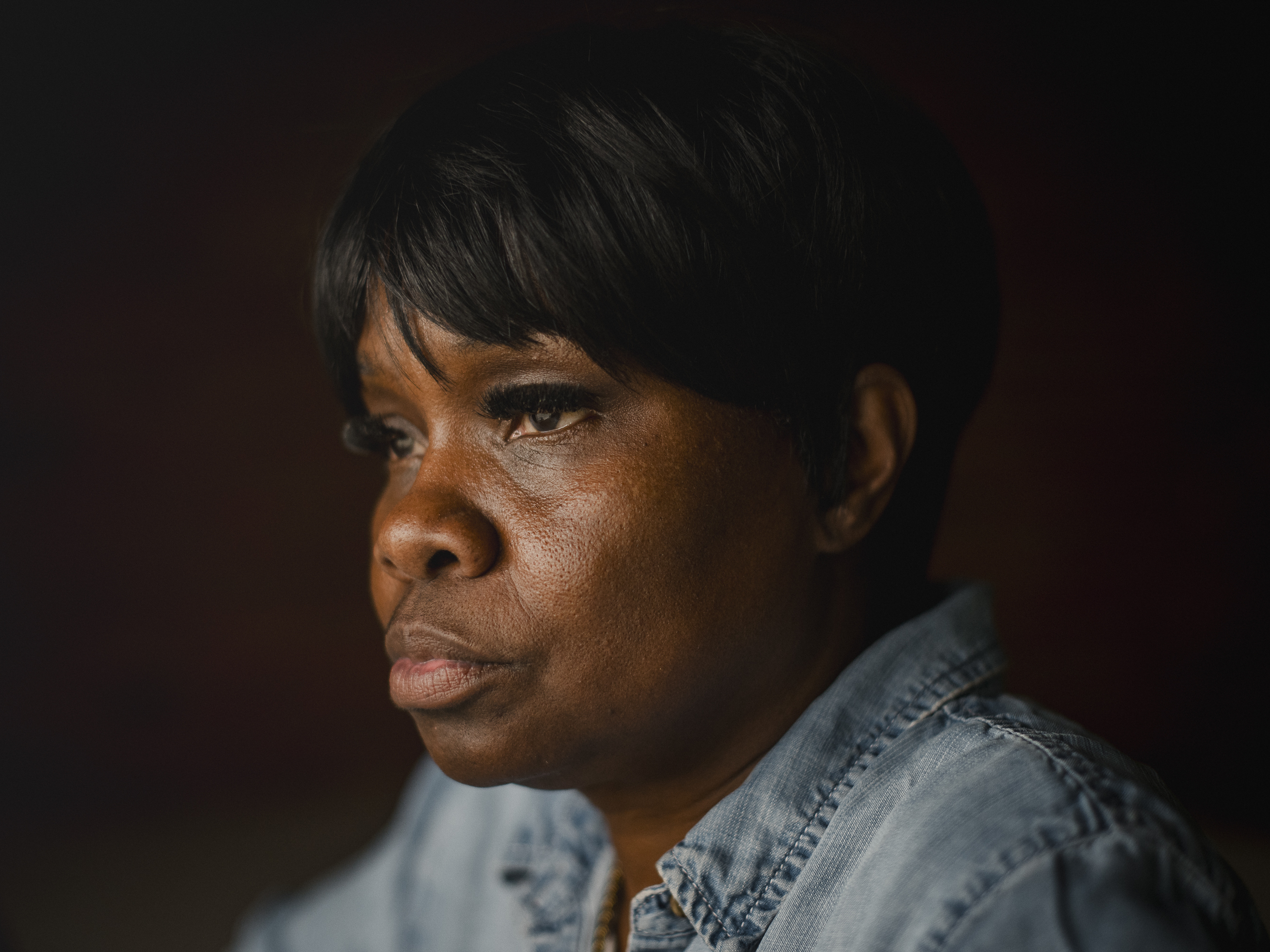 caption: Tanya Warden, 55, sits for a portrait at her workplace in Philadelphia on Tuesday, March 26 2024. Warden's son, Tyron Alexander, was shot multiple times and died in October 2020.