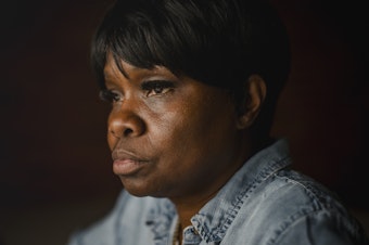caption: Tanya Warden, 55, sits for a portrait at her workplace in Philadelphia on Tuesday, March 26 2024. Warden's son, Tyron Alexander, was shot multiple times and died in October 2020.