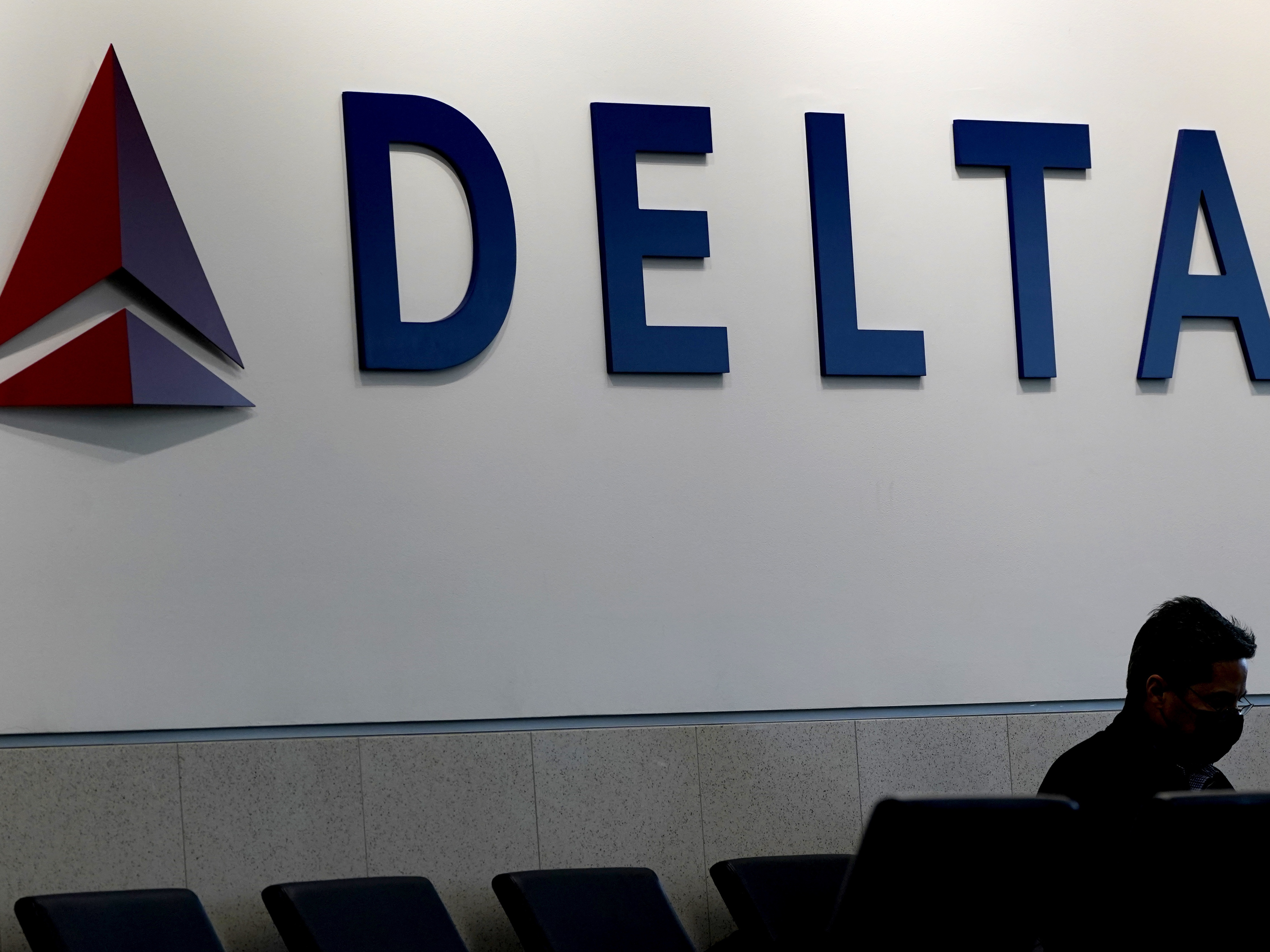 caption: A Delta aircraft clipped the tail of another plane on the tarmac Tuesday morning at Hartsfield-Jackson Atlanta International Airport, officials said. Here, a man is shown waiting for a Delta flight at Hartsfield-Jackson on Jan. 7, 2022. 