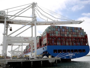 caption: A container ship sits in a berth at the Port of Oakland in California last year. President Trump announced additional tariffs on imports from China on Thursday.