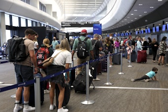 caption: Travelers line up to check in for United Airlines flights at San Francisco International Airport on July 1, 2022 in San Francisco, Calif. This summer is expected to be a record for air travel.