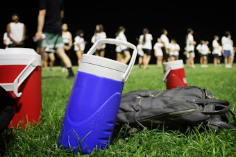 caption: Marching bands are getting creative to beat the heat of climate change. Some changes include covering brass instruments under direct sunlight, scheduling frequent water breaks and time to put on extra sunscreen, no longer wearing traditional marching band uniforms at games and practicing before sunrise or after sunset.