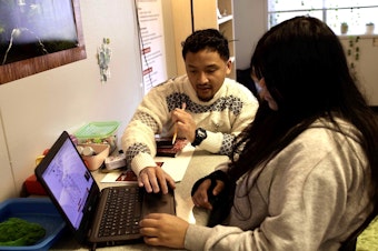 caption: Joshua Wisnubroto works with a student at ACES High School, his first school placement as part of the Washington Education Association's teacher residency program. 