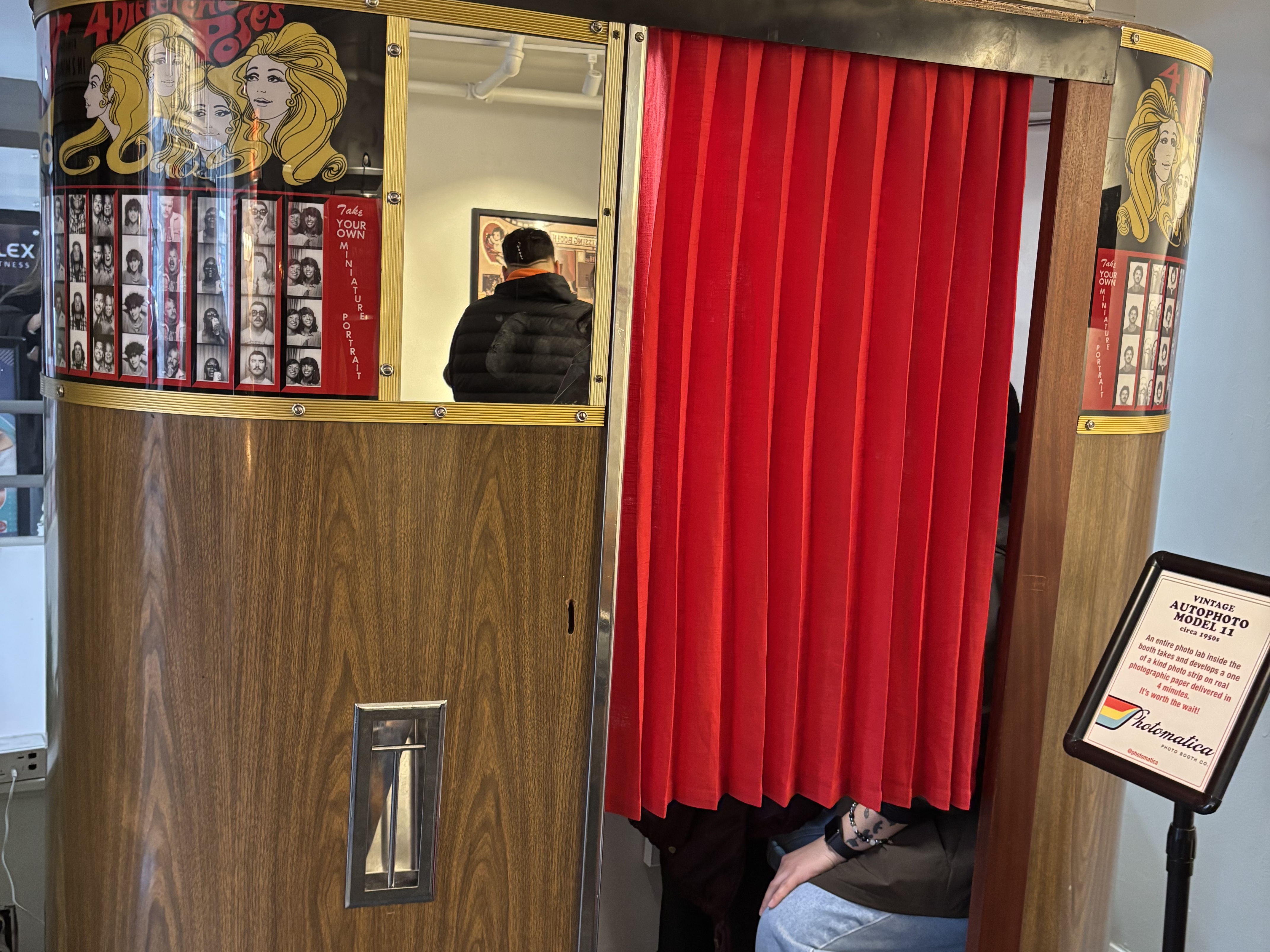 caption: Guests get cozy in a vintage machine at the Photo Booth Museum by Photomatica in San Francisco.
