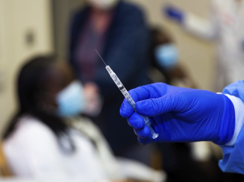 caption: A doctor prepares to administer a vaccine injection at New York-Presbyterian Lawrence Hospital on Friday.