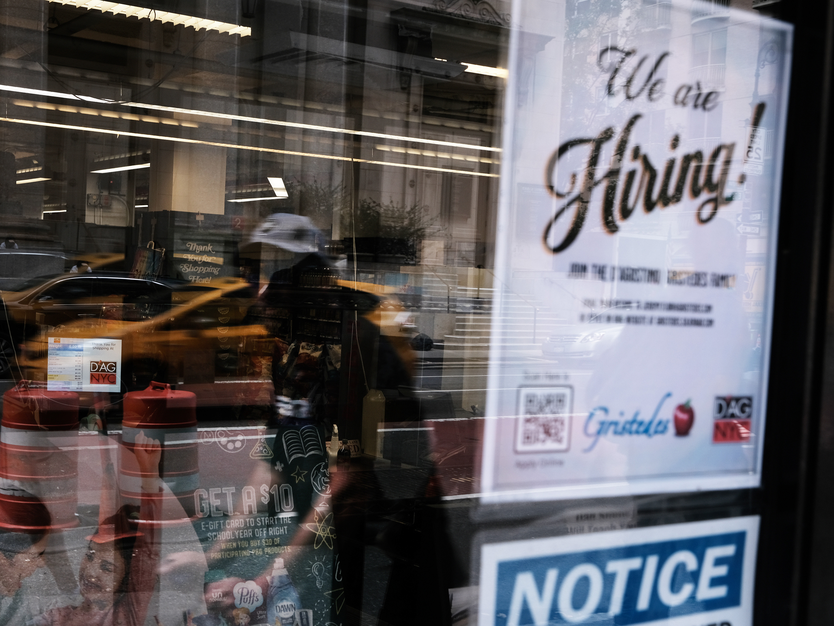 caption: A hiring sign gets displayed in a store window in New York City in August. Last month saw a sharp slowdown in hiring from previous months as the pandemic wears on and creates uncertainty.