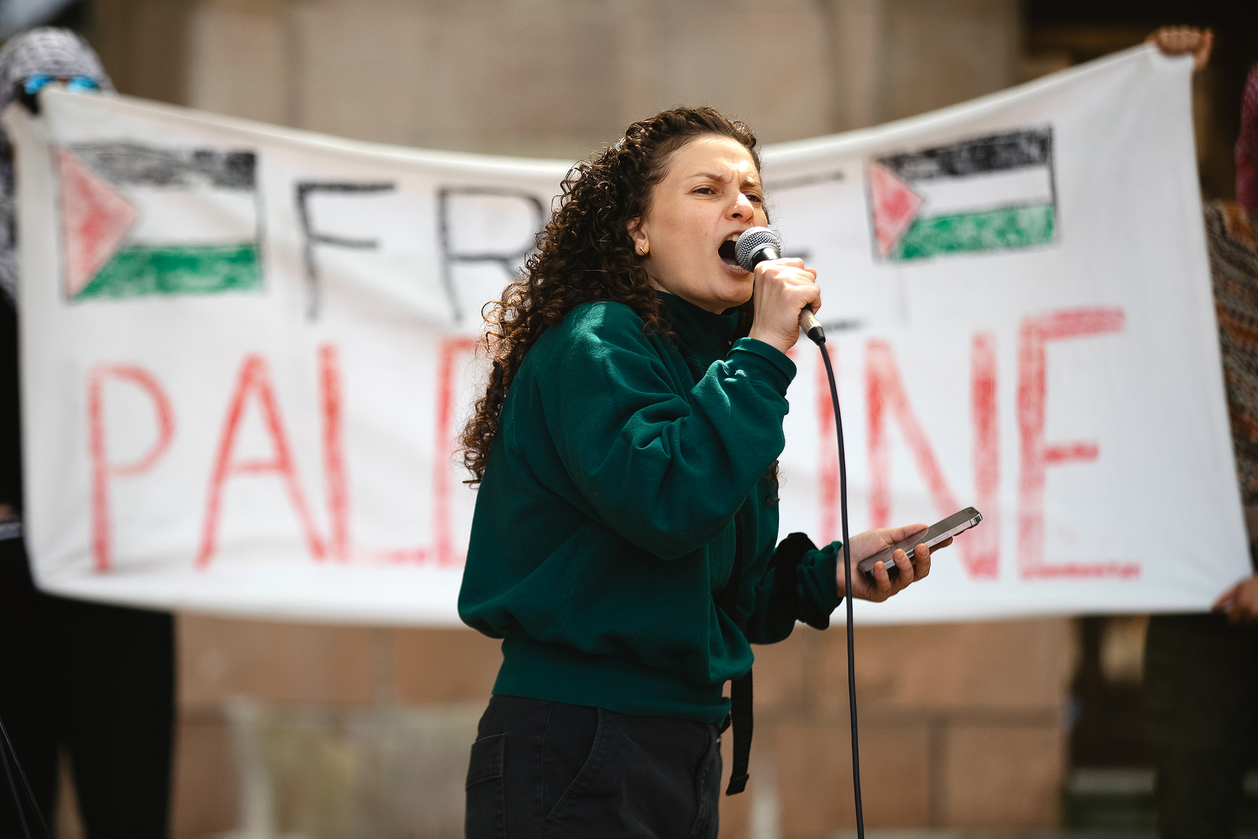 caption: Bissan Barghouti, an organizer with Nidal Seattle and the Masar Badil, speaks to crowd rallying outside of Gerberding Hall on Thursday, May 8, 2025, on the University of Washington campus in Seattle. 