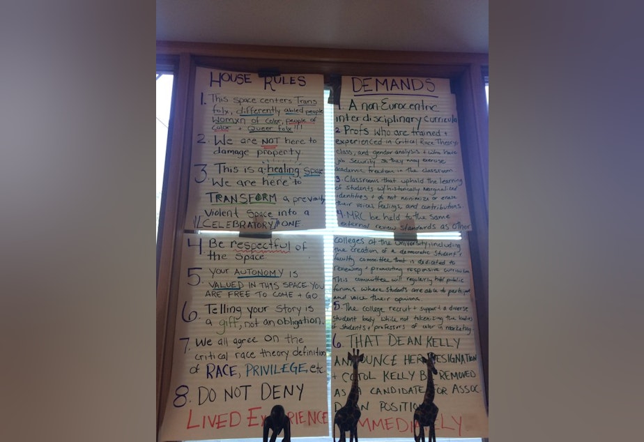 caption: Demands posted in a window of the occupied space at Matteo Ricci College.