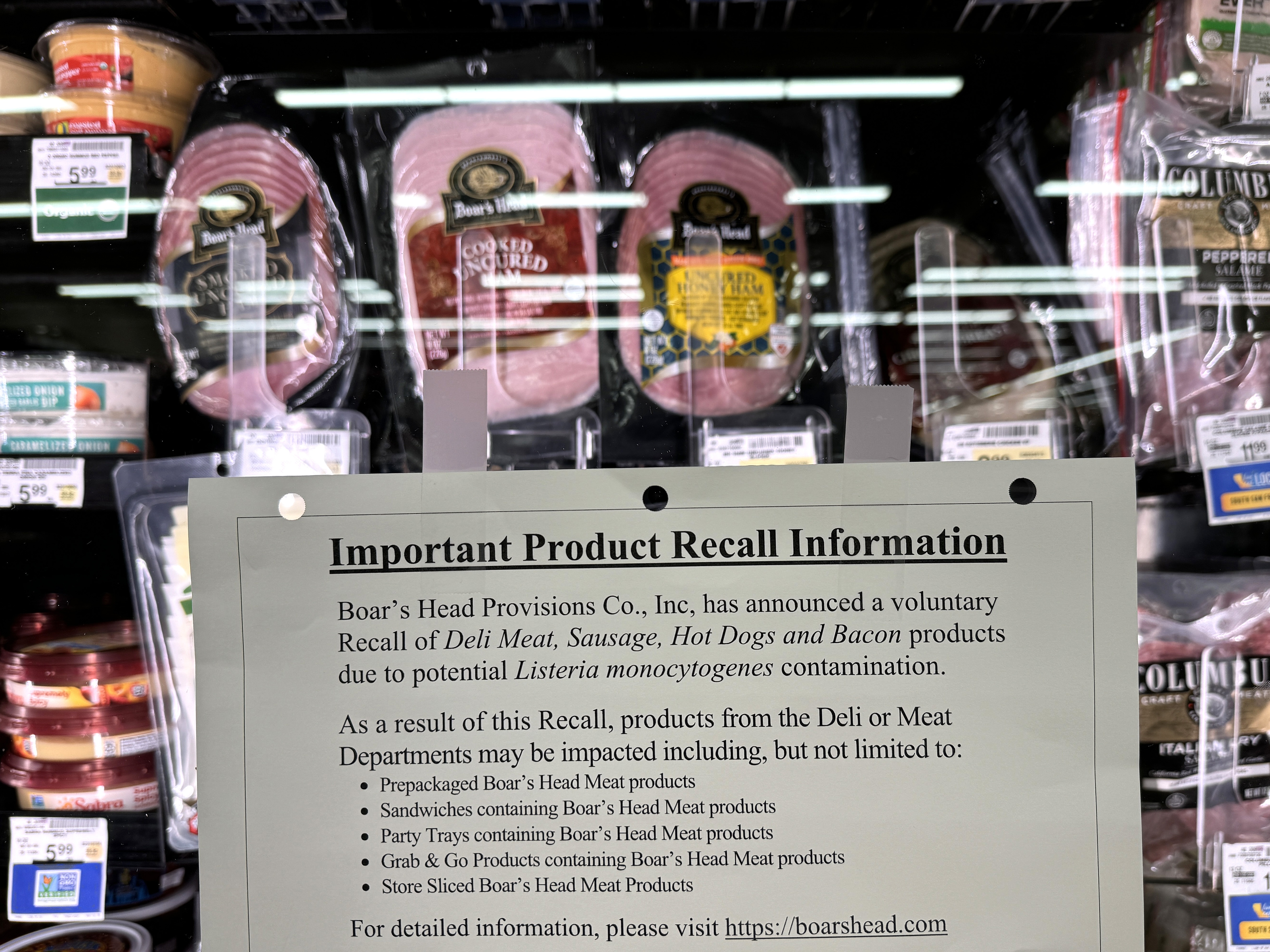 caption: A recall notice citing listeria contamination risks is posted next to Boar's Head meats in a Safeway store in San Rafael, Calif., in July, as the deli meat company expanded its recall of ready-to-eat meat and poultry products.