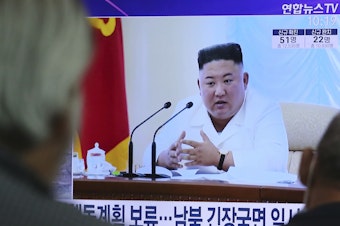 caption: North Korean leader Kim Jong Un appears in a TV news program watched by people in Seoul, South Korea, on June 24.