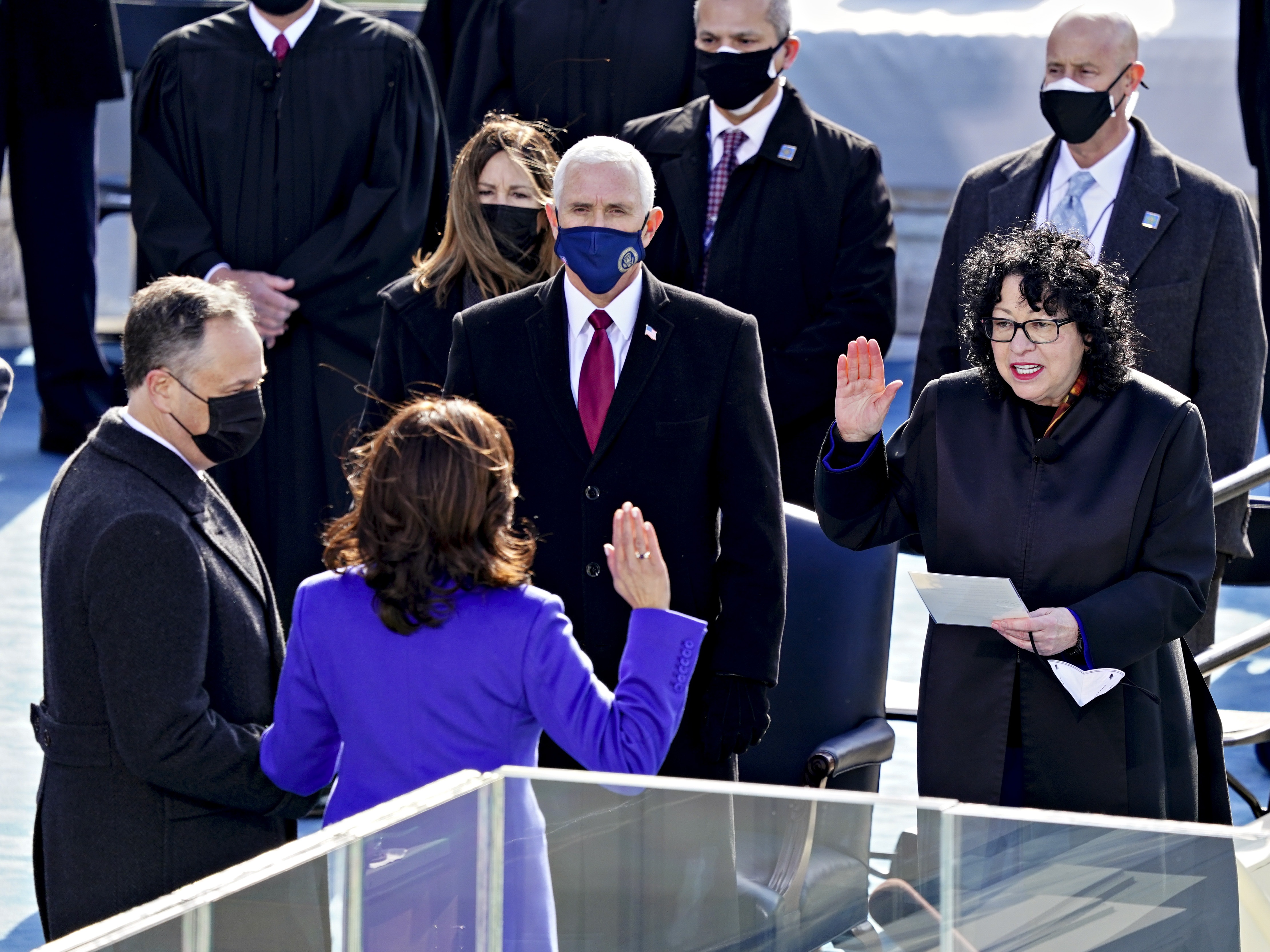 caption: Supreme Court Justice Sonia Sotomayor (right) administers the oath of office to incoming Vice President Kamala Harris in front of the U.S. Capitol on Jan. 20, 2021, as outgoing Vice President Mike Pence (wearing blue mask) watches.