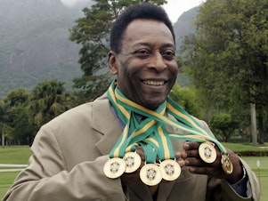 caption: Brazilian football legend Edson Arantes do Nascimento, better known as Pelé, poses with his six Brazil's champion medals in 2010. A Portuguese language dictionary has recognized his name as a synonym for greatness.
