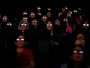 caption: Filmgoers watch a screening of Marvel Studios' <em>Avengers: Endgame</em> at a cinema in Caracas in April 2019. More than 50 workers at Marvel Studios in LA, New York and Atlanta have signed authorization cards to be represented by the International Alliance of Theatrical Stage Employees, or IATSE.