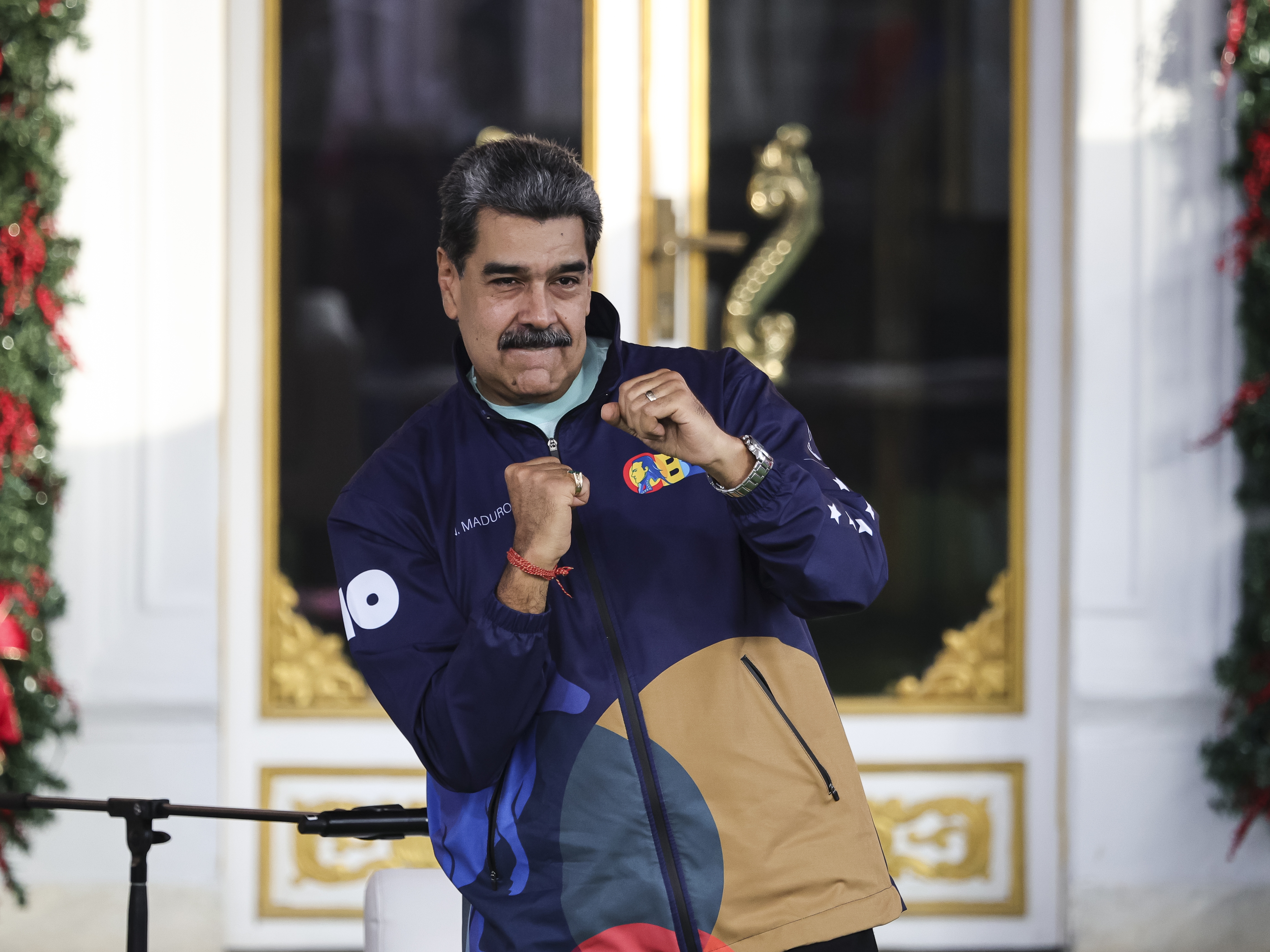 caption: President of Venezuela Nicolás Maduro dances during a march as part of the "Venezuelan Student Day" at Miraflores in Caracas, Venezuela, on Nov. 21.