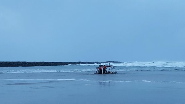 caption: Newport, Ore., examine the wreckage of the Mary B. II, a commercial crabbing that capsized while crossing Yaquina Bay Bar off the coast of Newport, Ore. Three crew members died in the accident. CREDIT: US COAST GUARD