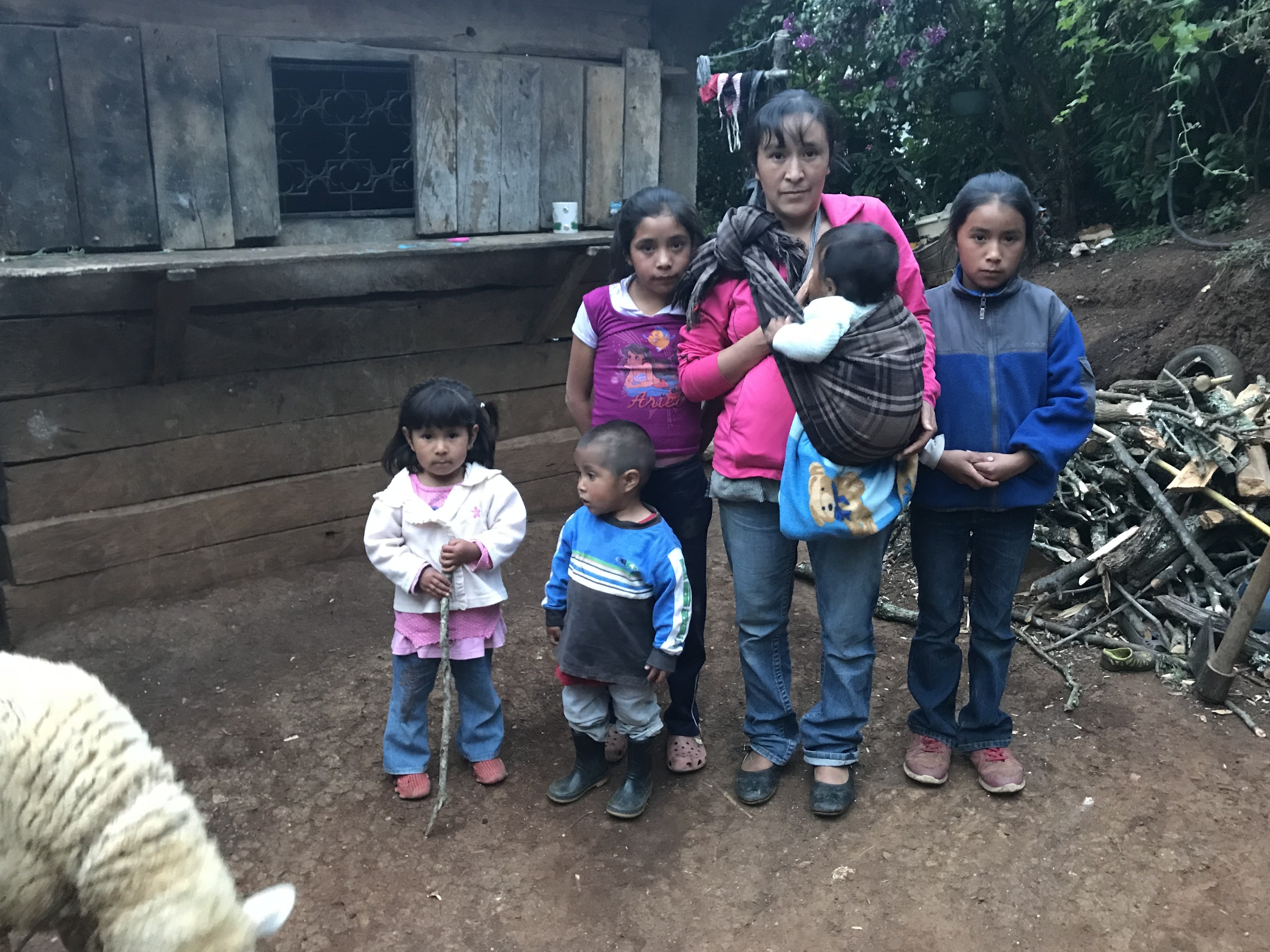 caption: Sara Cano with five of her six kids in front of her home in San Antonio Las Nubes, Huehuetenango, Guatemala. Her husband, Oscar Leonel Lopez, tried to immigrate to the U.S. but was deported back home.
