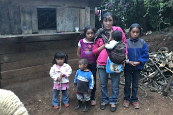 caption: Sara Cano with five of her six kids in front of her home in San Antonio Las Nubes, Huehuetenango, Guatemala. Her husband, Oscar Leonel Lopez, tried to immigrate to the U.S. but was deported back home.