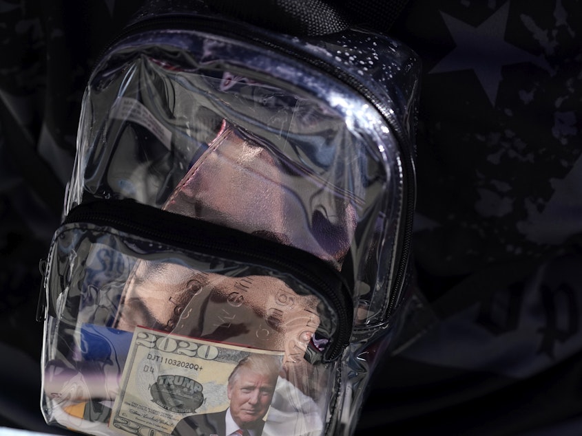 caption: A supporter of President Donald Trump has a clear plastic backpack during a campaign rally at MBS International Airport, Thursday, Sept. 10, 2020, in Freeland, Mich.