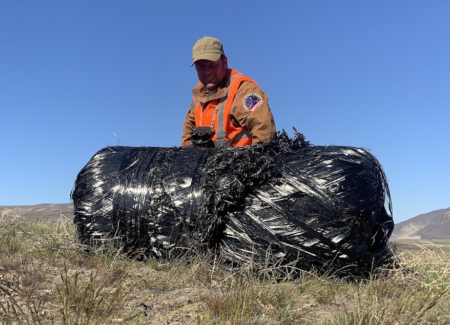 caption: Robert Ward posed with the second carbon fiber-wrapped rocket tank he found, which he located close to the Columbia River on the Yakima Firing Range.