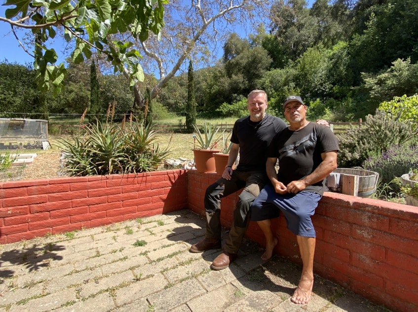 caption: Host Chris Morgan (left) sits in the backyard of Anthony Prieto (right) who advocates for hunters to use lead free ammunition to protect condors.  