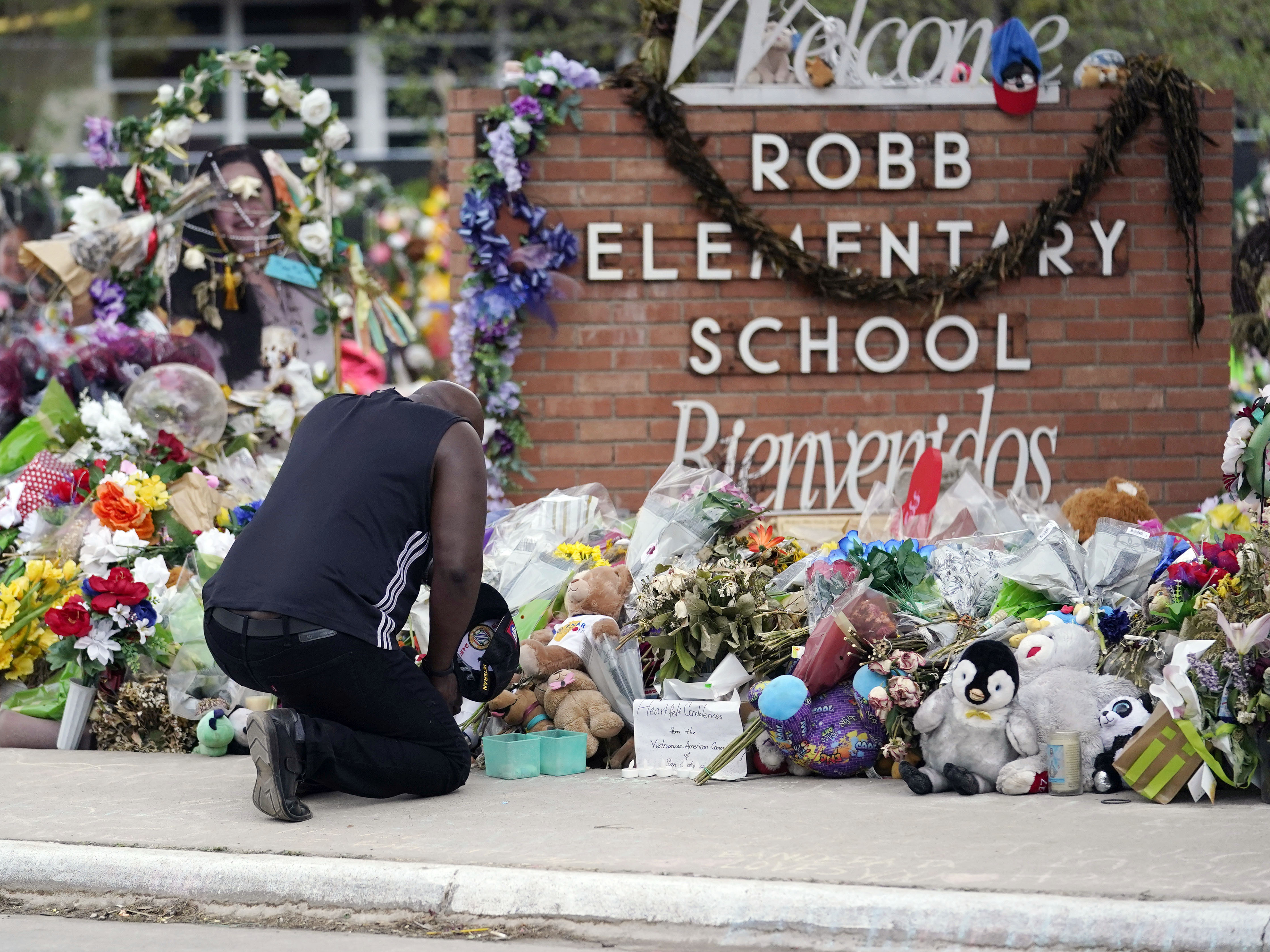 caption: Reggie Daniels pays his respects at a memorial at Robb Elementary School in Uvalde, Texas, on June 9, 2022, honoring the two teachers and 19 students killed in the shooting at the school on May 24.