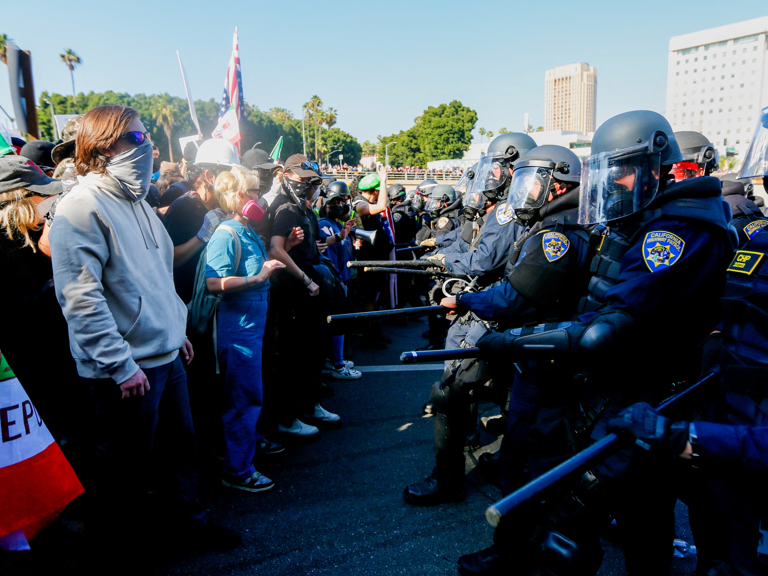caption: California Highway Patrol officers attempt to control crowds on the 101 Freeway during an anti-ICE protest in downtown Los Angeles on Sunday. Protests erupted after a wave of federal immigration raids began around the city, with National Guard troops deployed despite objections from local officials.