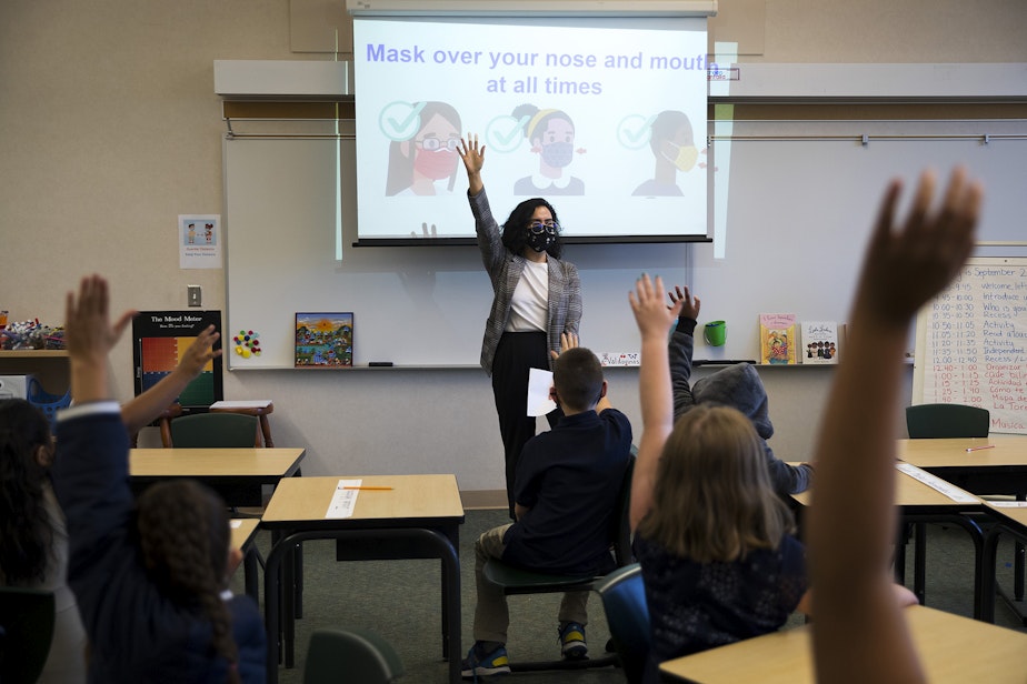 caption: Third grade teacher Lucero Heredia-Valdovinos talks with students about masks during the first day of school at Mount View Elementary school on Thursday, September 2, 2021, in Seattle. 