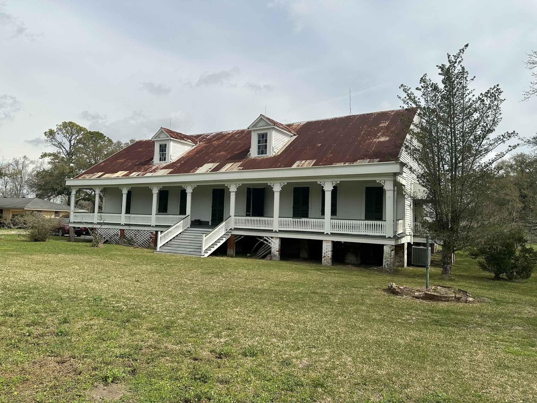 caption: The Woodland Plantation House sits near the banks of the Mississippi River in LaPlace, La. The raised creole-style building with a rusty tin roof and wide front porch has Black owners for the first time. The site is historically significant because it's where one of the largest slave revolts in U.S. history began.