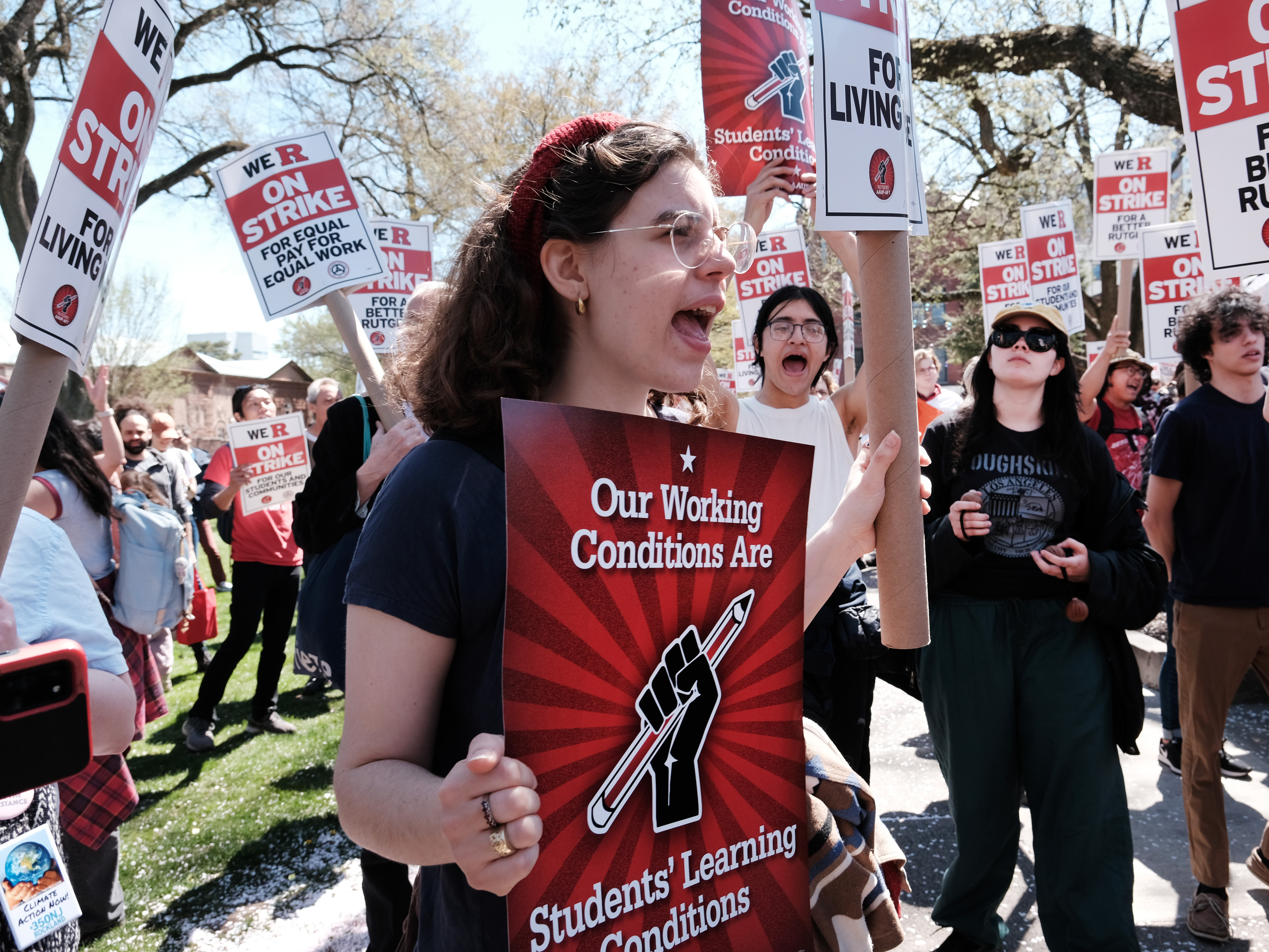 caption: Rutgers students and faculty participate in a strike at the university's main campus on Monday.