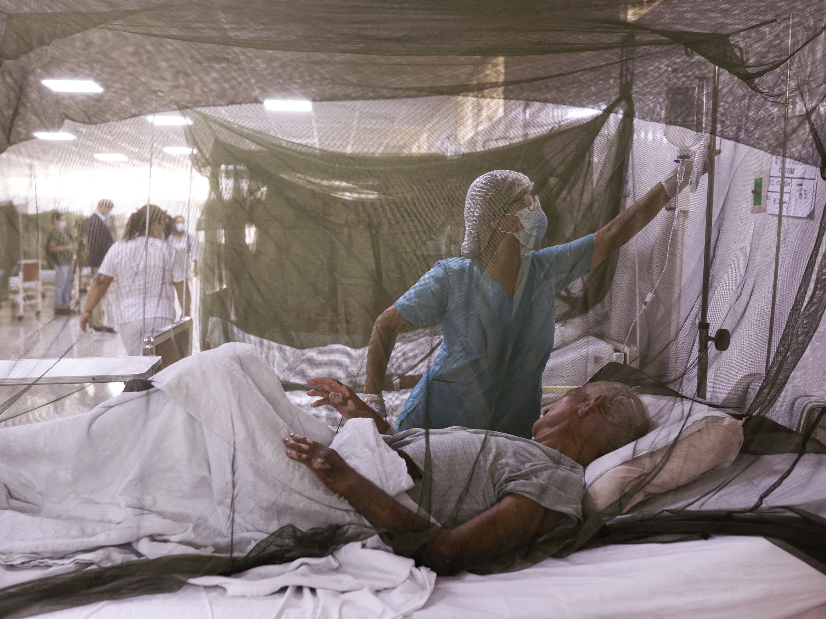 caption: A nurse takes care of a patient at a hospital near Lima, Peru. The country experienced an outbreak of dengue fever in 2024 — a pattern that was replicated in many countries around the world. A new study suggests climate change may be contributing to the spread of the mosquito-borne disease.