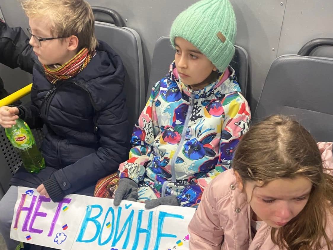 caption: Children were detained in Moscow on Tuesday, after trying to leave flowers at Ukraine's embassy. They were carrying signs that read, "No to War."