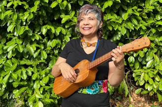 caption: The author's mother, Michelle Habell-Pallán, playing her jarana in her backyard in Seattle.
