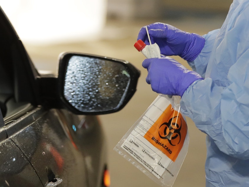 caption: A nurse at a drive up COVID-19 coronavirus testing station, set up by the University of Washington Medical Center in Seattle.
