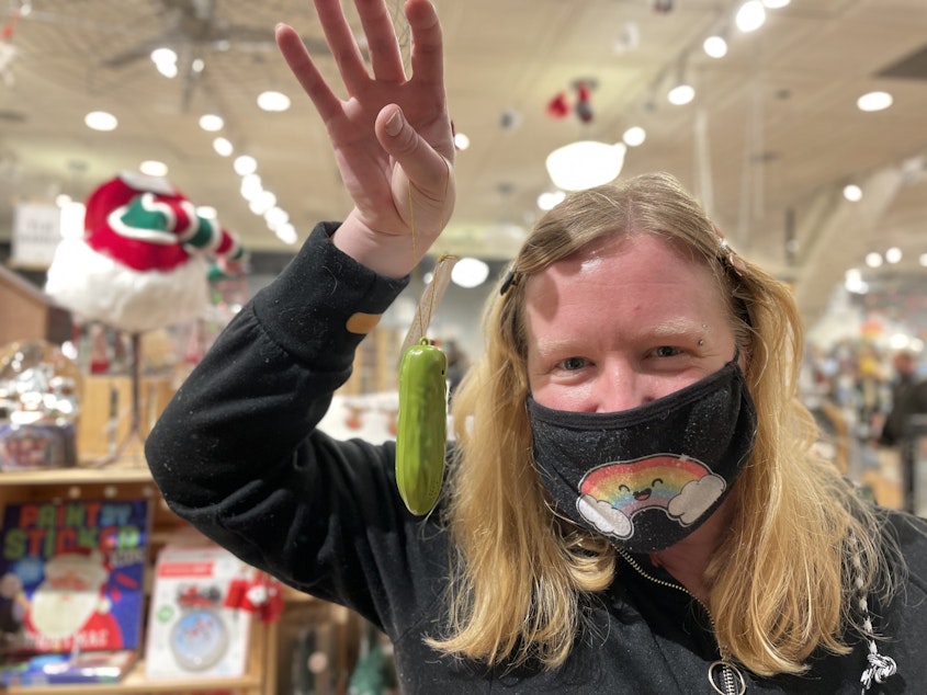 caption: Sarah Kennedy at Fireworks in Westlake Center holds up a yodeling pickle Christmas ornament, a popular item at her store
