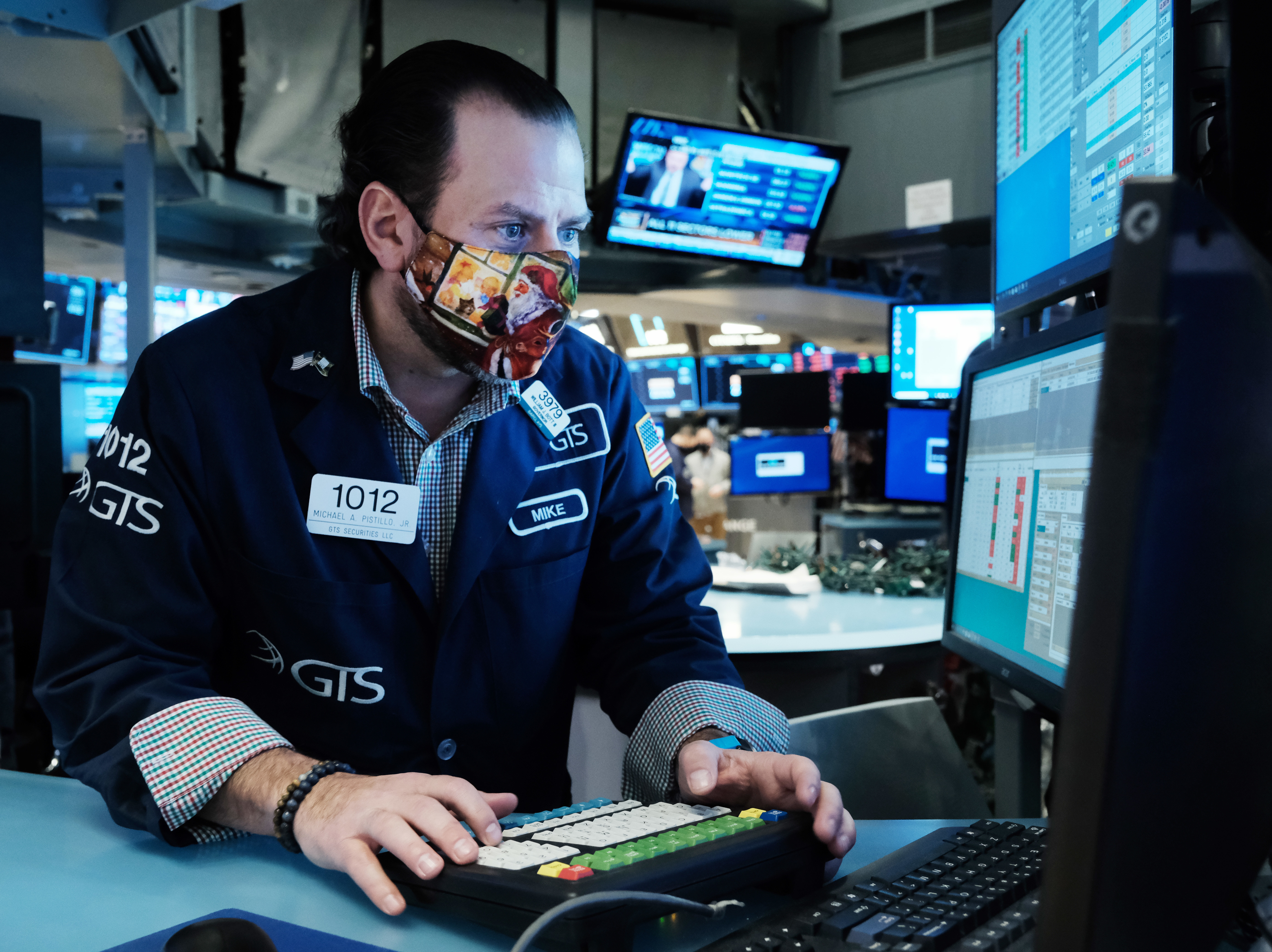 caption: A trader works on the floor of the New York Stock Exchange at the start of trading on Monday. Stocks around the world tumbled over fears of the omicron variant.