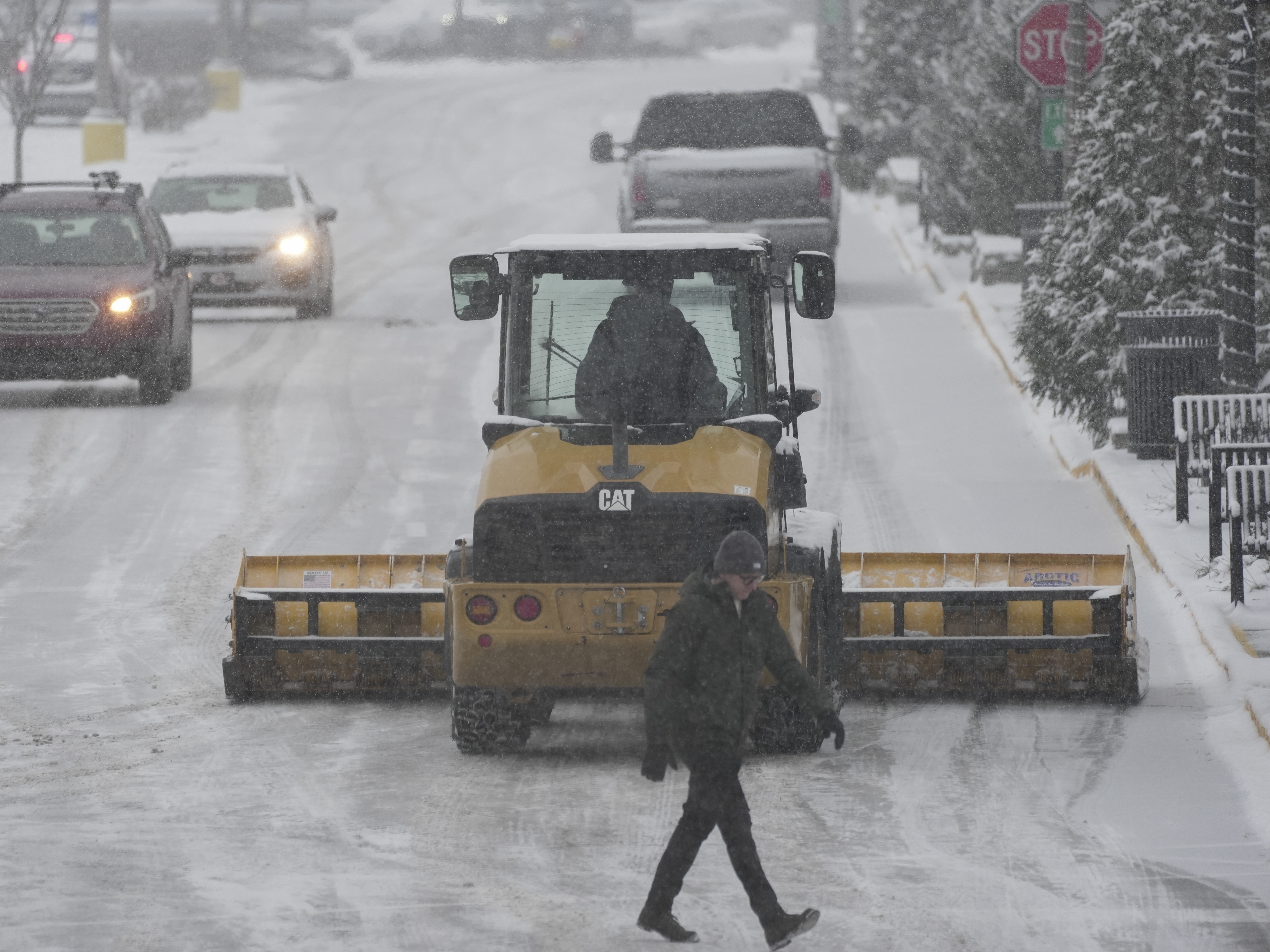 caption: A plow clears a parking lot during a winter storm on Sunday in Cincinnati.